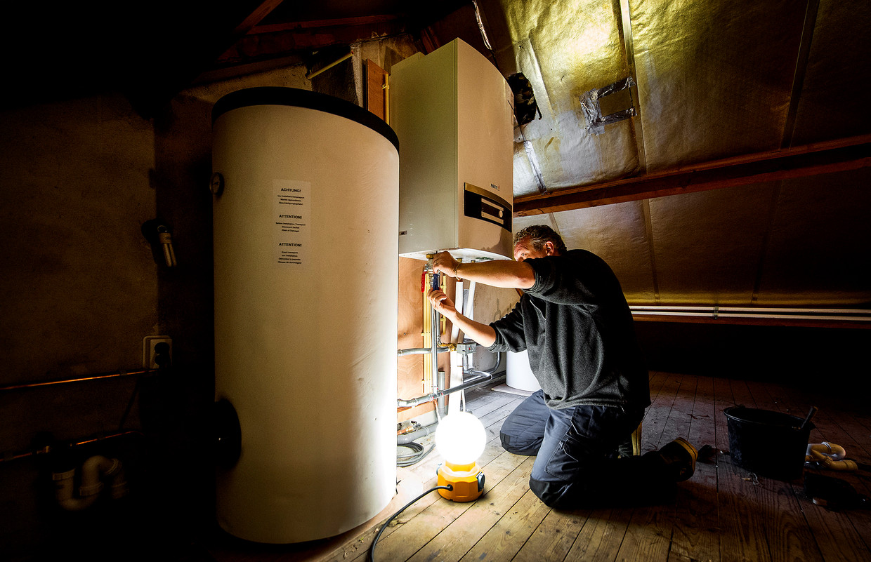 Installatie van een warmtepomp bij een verwarmingsketel in een woning in Lage Zwaluwe.  Beeld Hollandse Hoogte, ANP